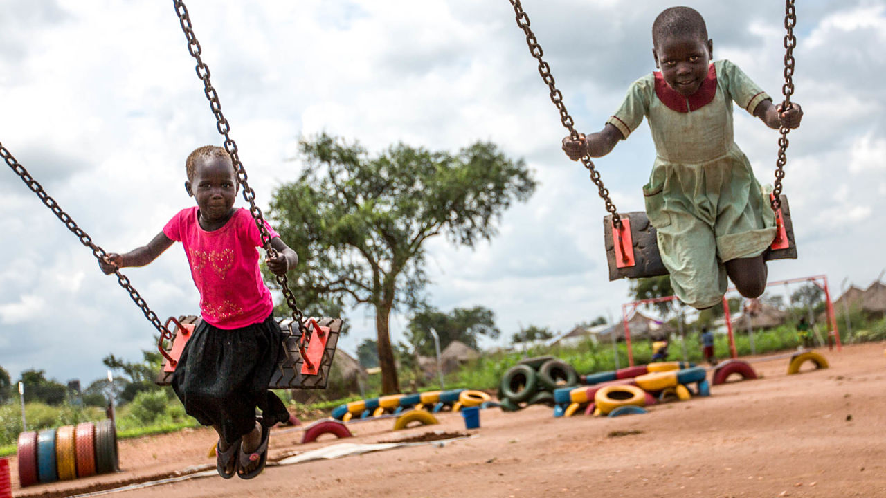 Children play on swings in the newly opened settlement Omugo
